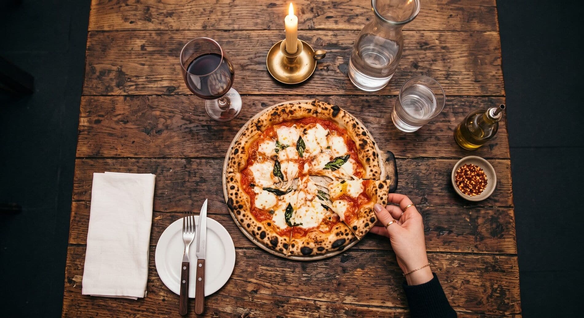 Une pizza margherita partagée à table, vue de dessus